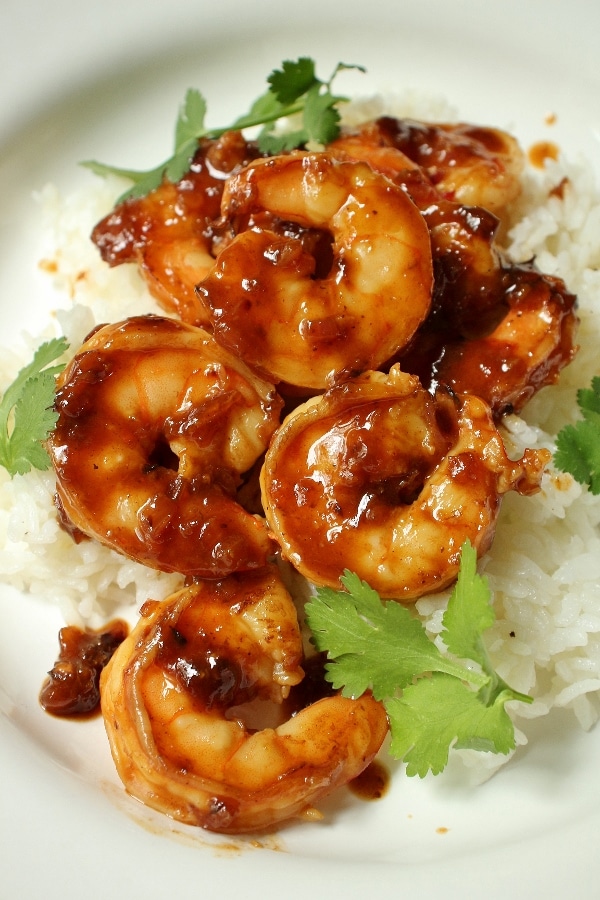 overhead view of pomegranate sriracha shrimp served over white rice