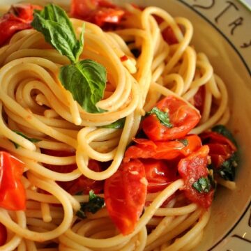 a bowl of spaghetti with tomato and basil sauce