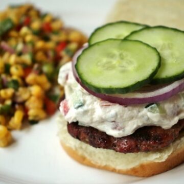 Burger with Chevre cheese, cucumbers, and red onions, with side of corn salad