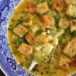 A bowl of Czech garlic soup topped with rye croutons.