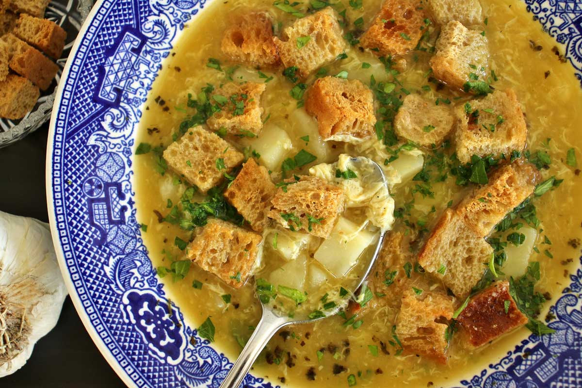 A bowl of Czech garlic soup topped with rye croutons.