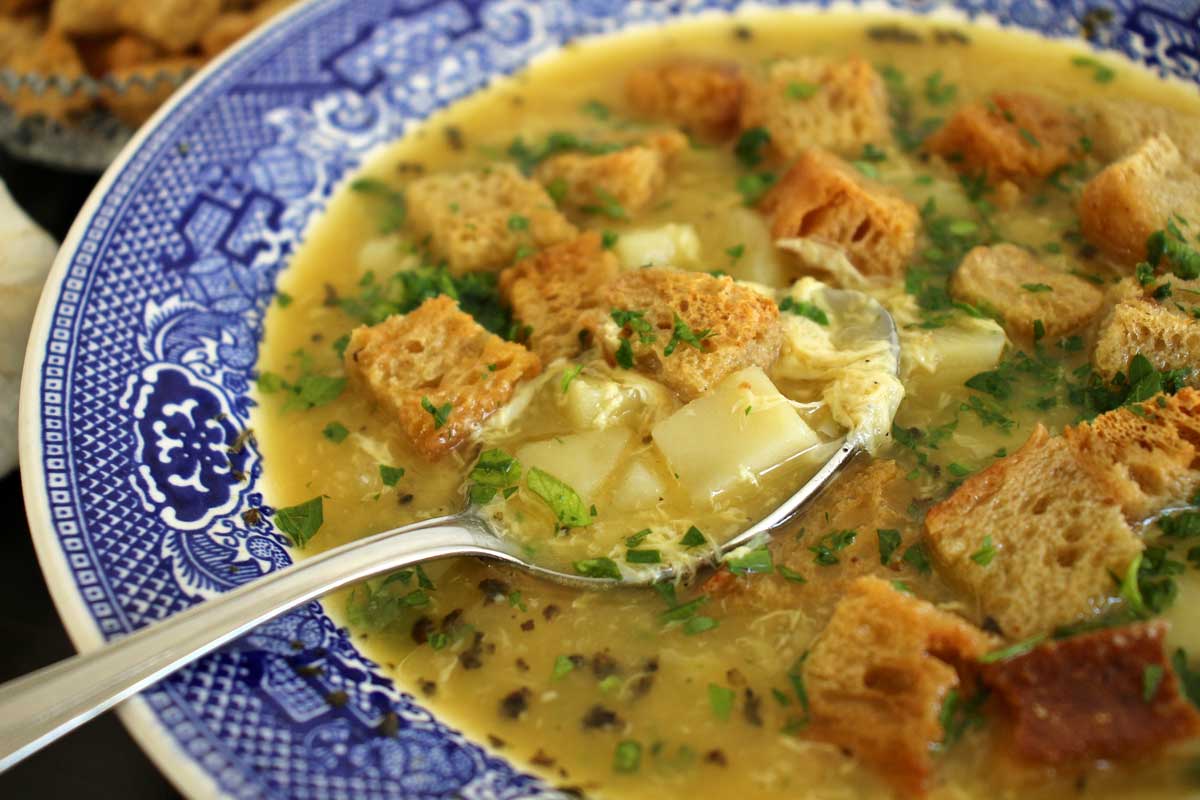 A bowl of cesnecka soup with a spoon scooping some up.