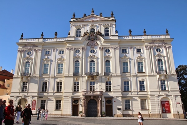 a tall ornate building with statues on the roof