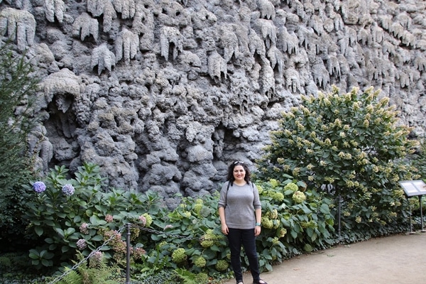 A person standing in front of a large rock