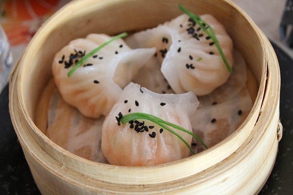 a steamer basket with 3 shrimp dumplings