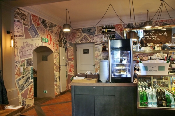 interior of a small restaurant with images of stamps on the walls