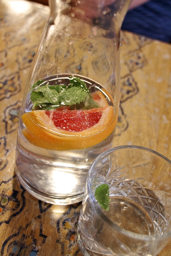 a bottle of water with sliced fruit and mint in it