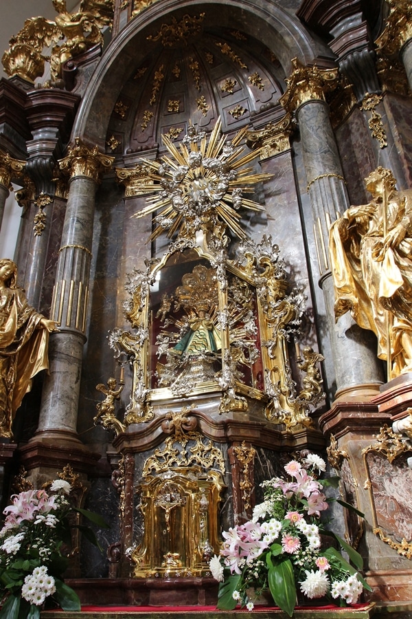 the Infant Jesus of Prague statue surrounded by gold adornments