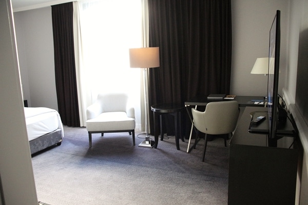 A hotel room with a desk and a lamp