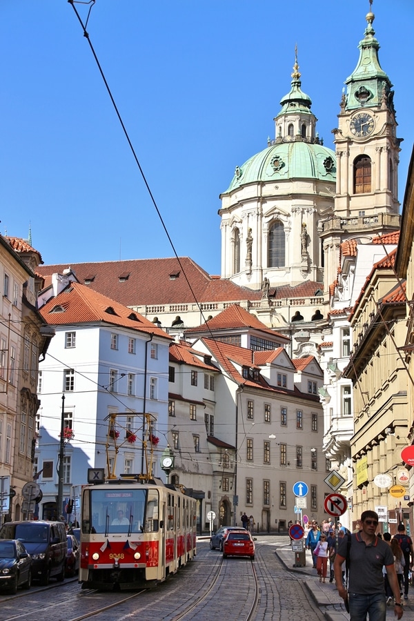 a tram driving down a cobblestone street in Prague