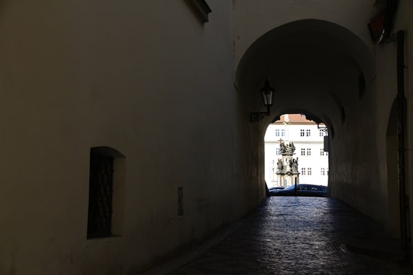 a dark tunnel leading to a square