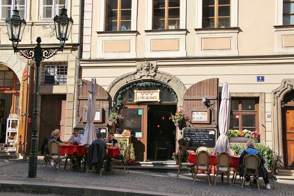 a restaurant with tables on the cobblestone sidewalk