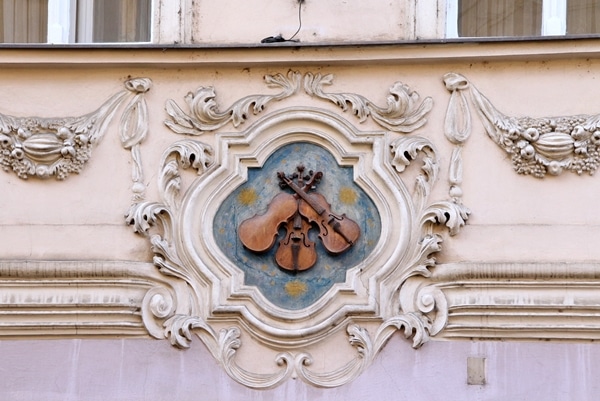 a decorative emblem of 3 violins on a blue background