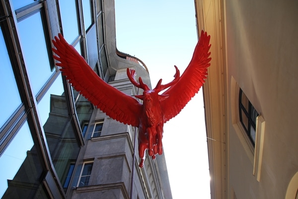 a red statue of a bull hanging above