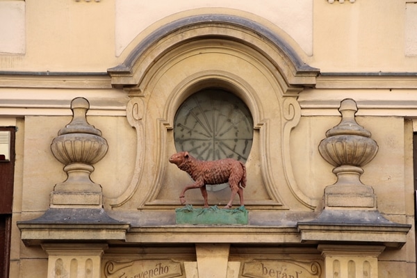 a statue of a red sheep over a doorway