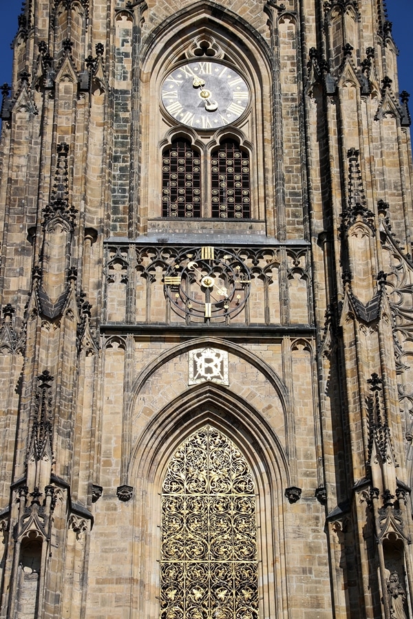 closeup of a clock on the exterior of a large stone church