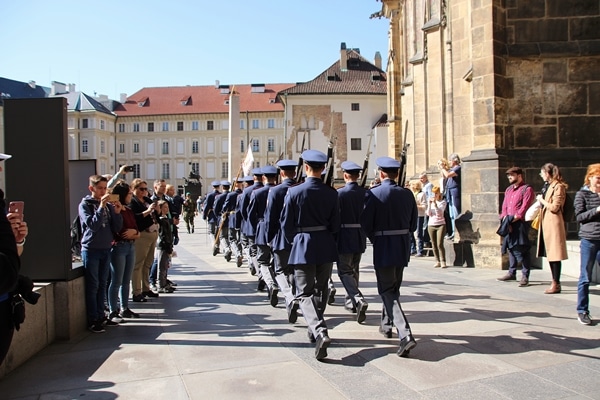 soldiers in blue uniforms marching through a square