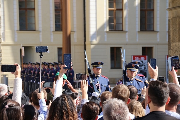 A group of people watching a ceremony with soldiers