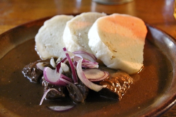 beef goulash stew with sliced dumplings on the side