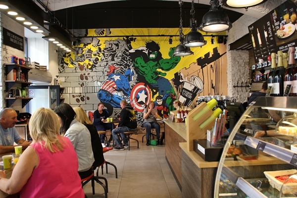 interior of a cafe with superheros painted on the far wall