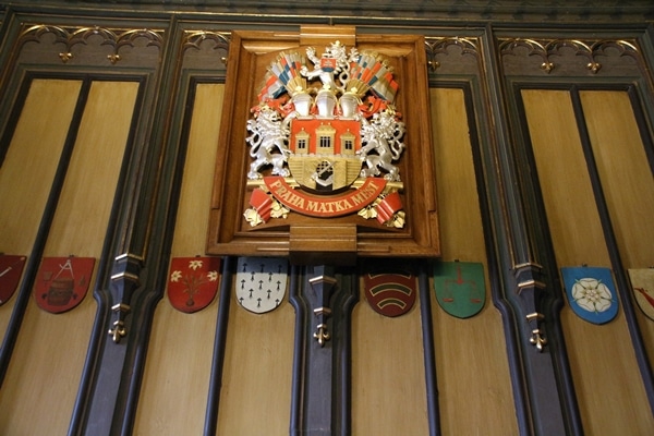 ornate decorations, emblem and wood paneling on a wall