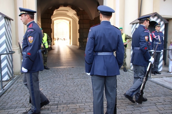 3 soldiers in blue uniforms in front of a tunnel