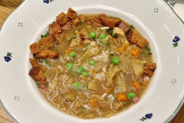 a bowl of rice and pea soup with croutons