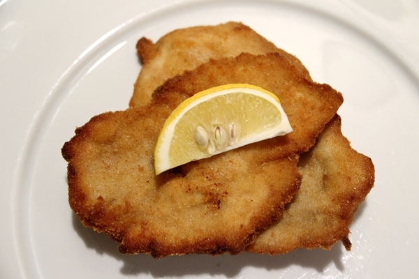 2 pieces of fried pork schnitzel with a lemon wedge