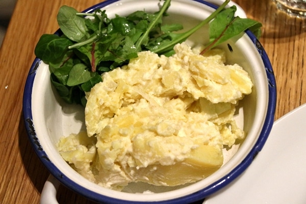 potato salad with a side of greens in a wide bowl