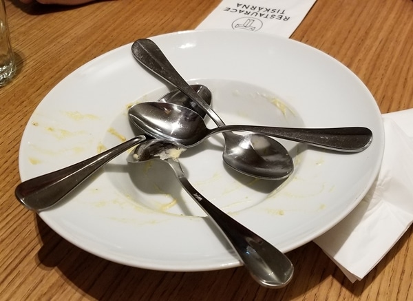 an empty white dish with 4 spoons