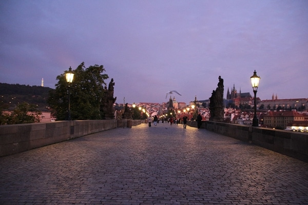 A nearly empty Charles Bridge in Prague at dawn