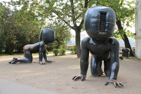 metal statues of crawling babies without faces