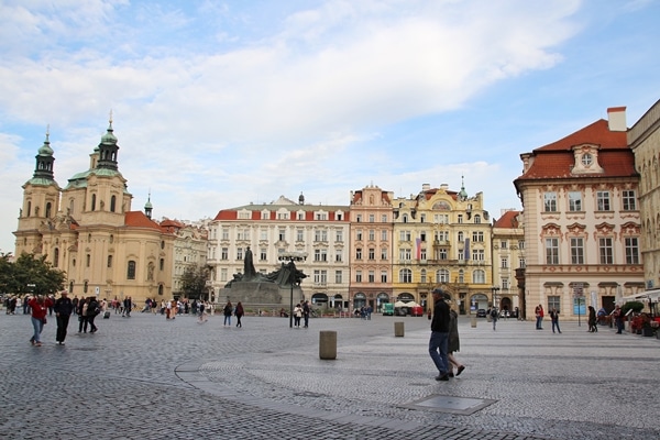 a wide view of a square in Prague with a few people walking through it