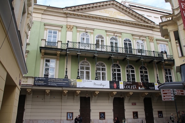 a mint green building with a long balcony