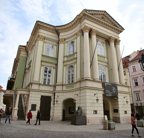 a mint green and ivory colored building with columns in front