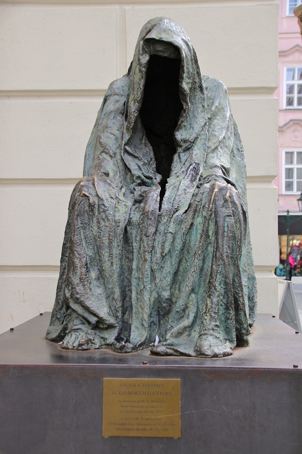 a metal statue of a cloaked man