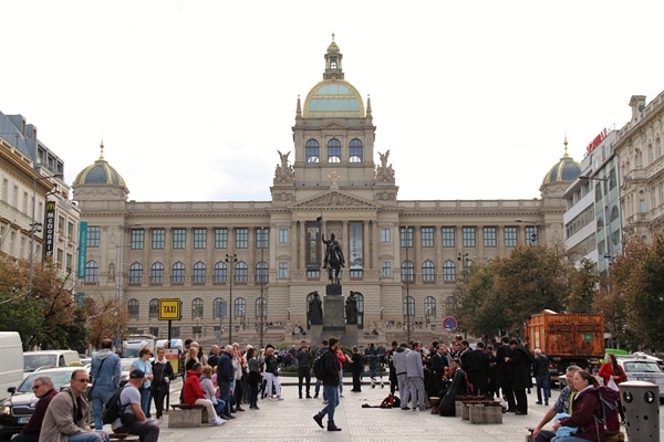 A group of people walking in front of the National Museum in Prague