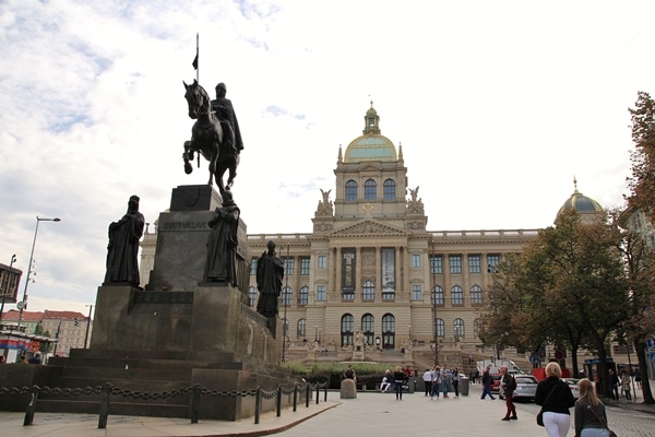 a statue of a man on a horse in front of a large building