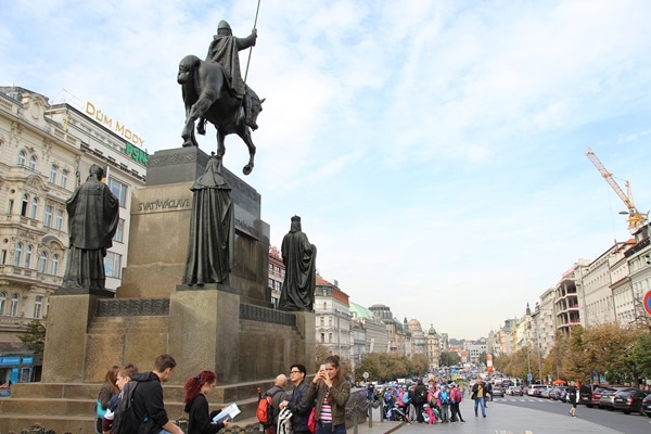 a statue of a man on a horse in a large square filled with people