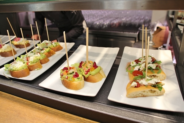 plates of open-faced sandwiches with skewers in them