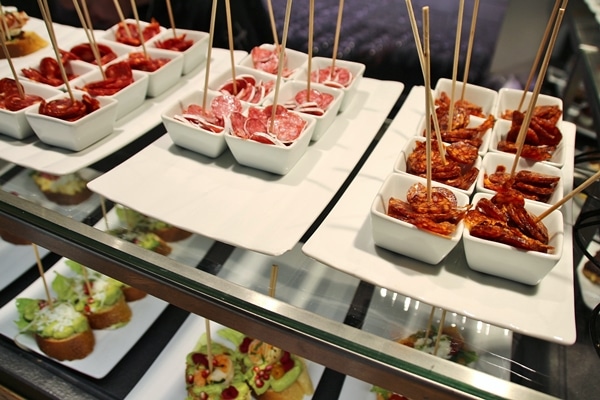 small dishes of food with skewers in them