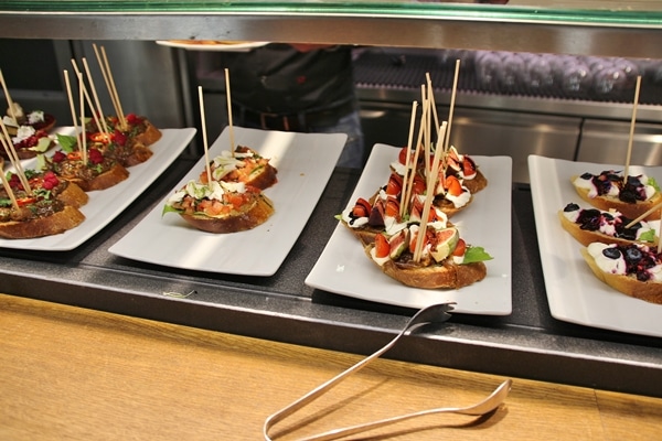 a buffet of open-faced sandwiches with skewers in them