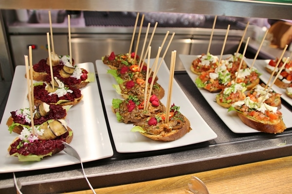 open-faced sandwiches on white plates with skewers sticking out