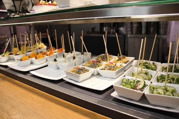 small white dishes filled with food with skewers sticking out