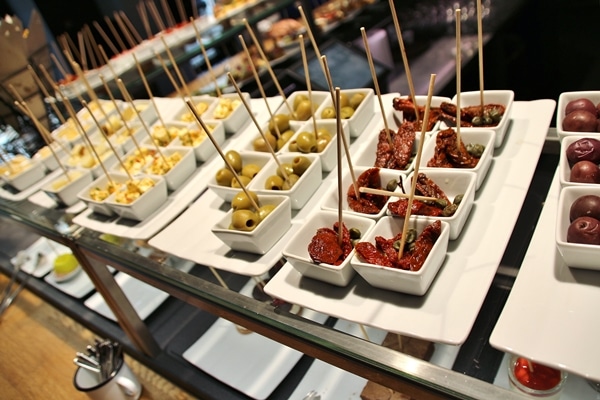small white dishes filled with food on a buffet line