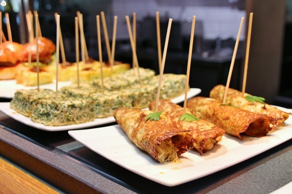 a buffet of various foods skewered with wooden sticks