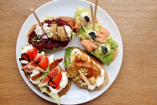 4 open-faced sandwiches on a white plate