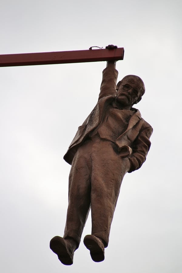 a statue of a man hanging from a pole