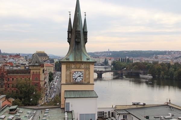 a clock tower on the edge of a river