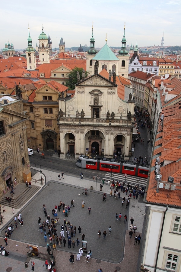 an overhead view of a Prague square with a tram running through it